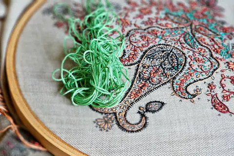Ricamo paisley nel telaio con filo verde