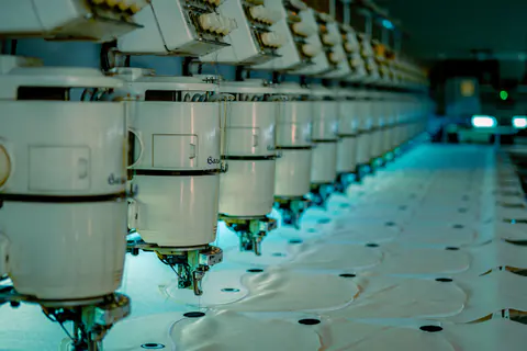 Fila di ricamatrici multitesta in un laboratorio
